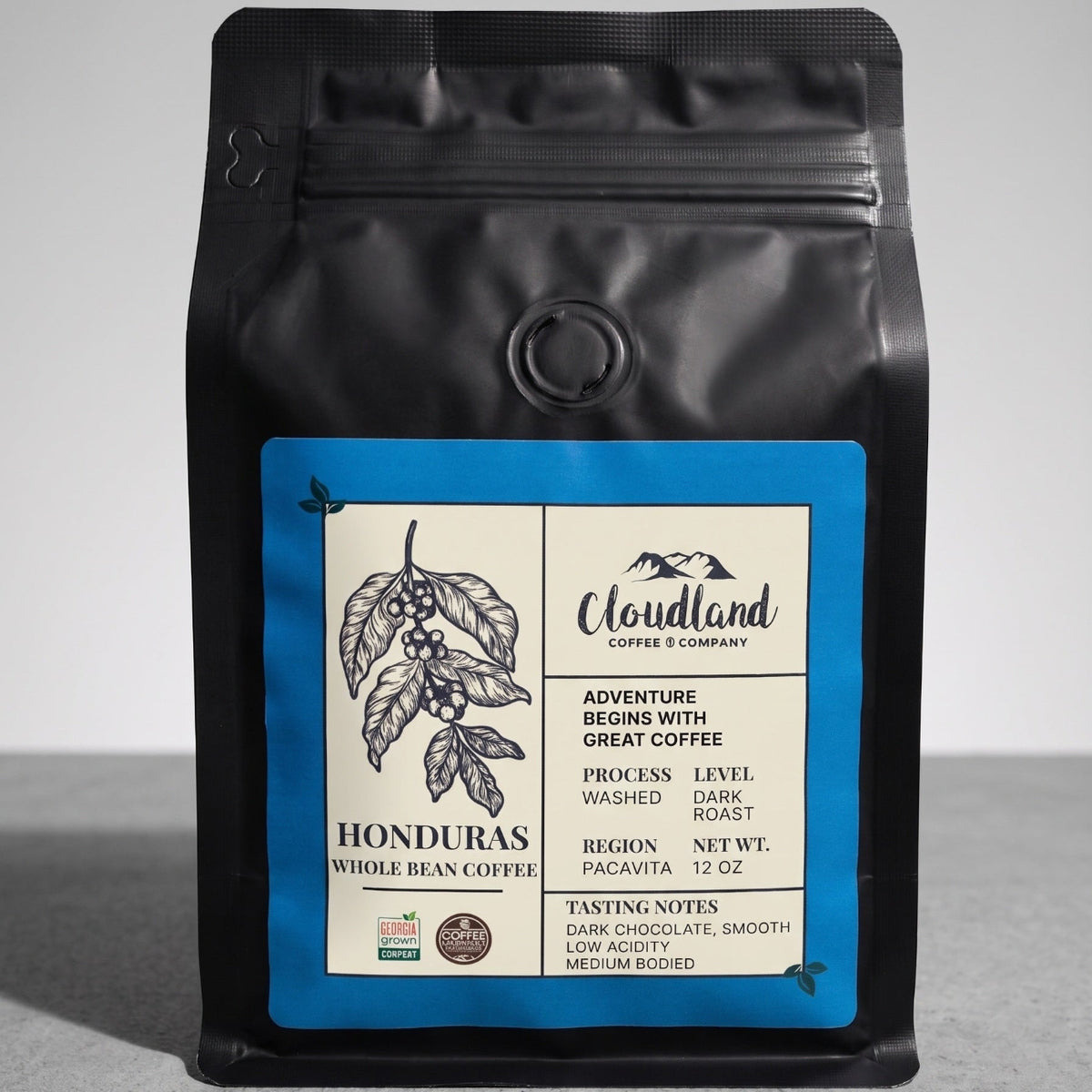 Black coffee bag with a label on a gray background