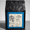 Black coffee bag with a label on a gray background
