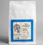 White coffee bag with a blue label featuring Cloudland Coffee Company branding on a gray background