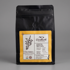 Black coffee bag of dark roasted Colombian coffee with yellow label on a gray background