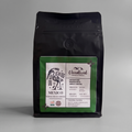 Black coffee bag of dark roasted Mexican coffee with a green label featuring Cloudland Coffee branding on a gray background